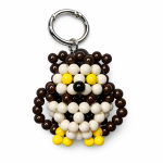 Brown and ivory beaded owl bag charm with yellow details and a silver-tone ring on a white background