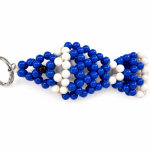 Blue and white handmade evil eye fish bag charm on a white background