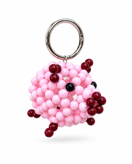 Pink beaded pig bag charm with burgundy details, black eyes and a silver-tone ring on a white background