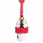 Berry Bloom wooden bead cup carrier holding a 12 oz takeaway cup