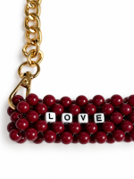 Close-up of burgundy beads, LOVE lettering and a gold-tone clasp on the LOVE IT cup carrier