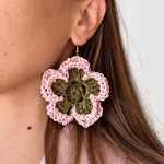 Pink and olive green layered bloom raffia flower earring worn on the ear with a gold-tone hook