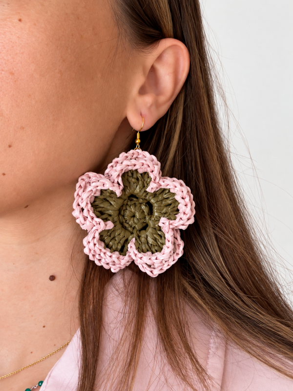 Pink and olive green layered bloom raffia flower earring worn on the ear with a gold-tone hook