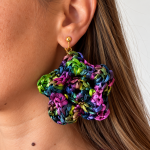 Multicolor raffia flower statement earring in blue, green, purple and pink worn on the ear