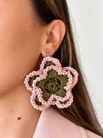 Pink and olive green open bloom raffia flower earring worn on the ear with a silver-tone fastening